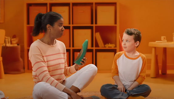 Teacher looking at a green shoe with a student