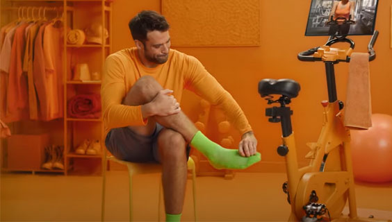 Person rubbing foot with green socks on